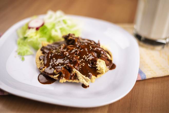 Tostada de pollo bañada en mole