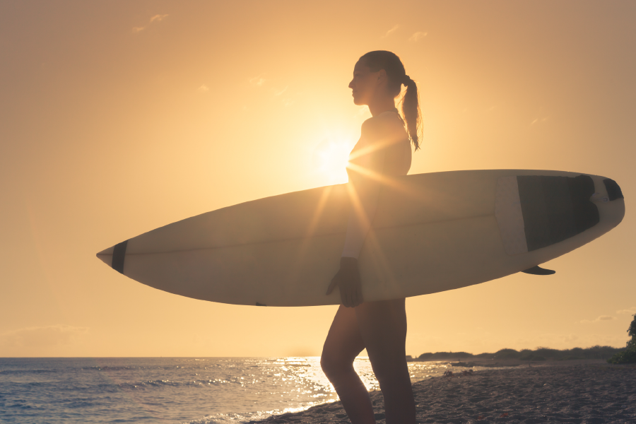Chica surfeando en Punta del Este al atardecer