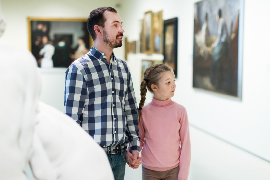 Familia observando las obras de arte de un museo