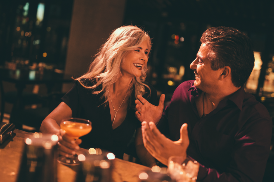 Pareja conversando y riendo durante una cena