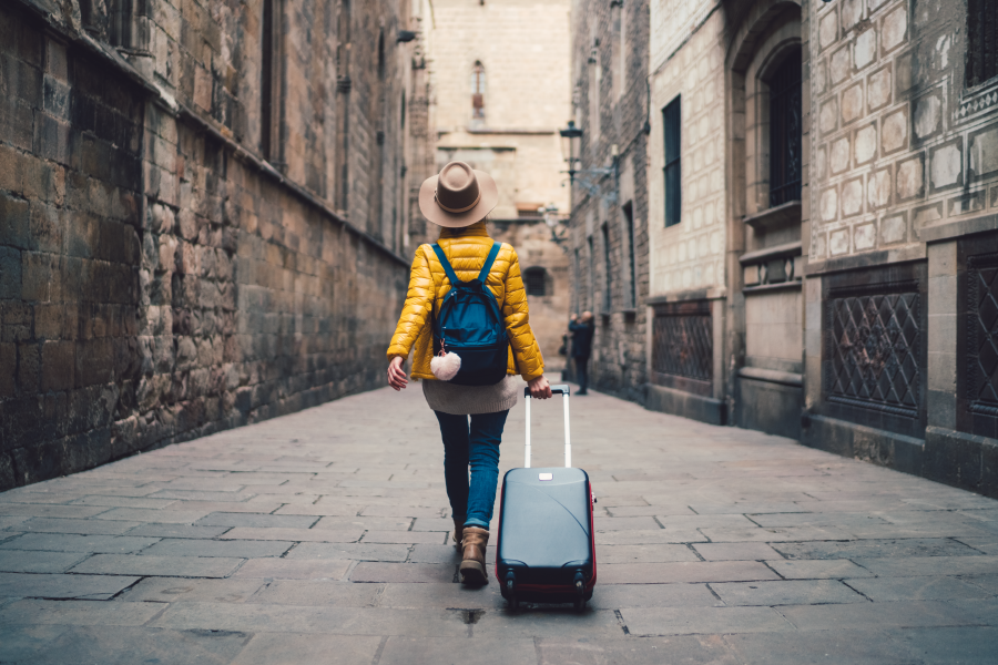 Una mujer pasando por la ciudad con su maleta