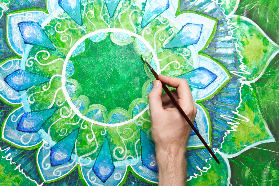 Una persona pintando una mandala verde