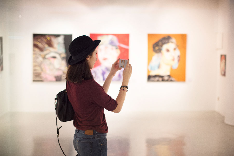 Mujer sacando una foto en un galería de arte