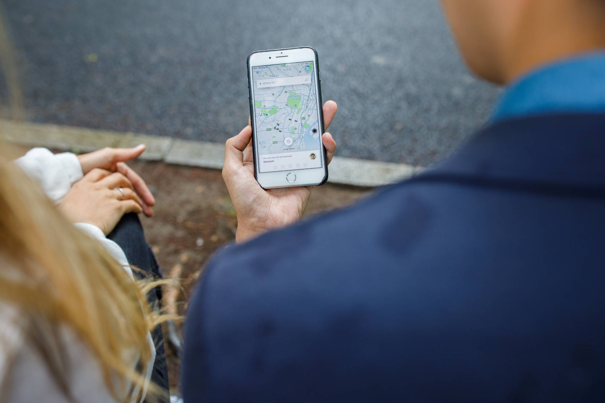 What is Uber doing to reduce the carbon footprint of ground travel? Man using the Uber app