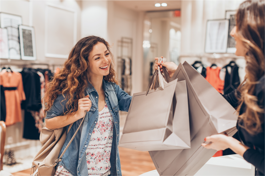 Mujer en una tienda de ropa con bolsas de compras