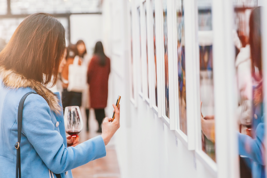 Una mujer sacando una foto en una galería de arte