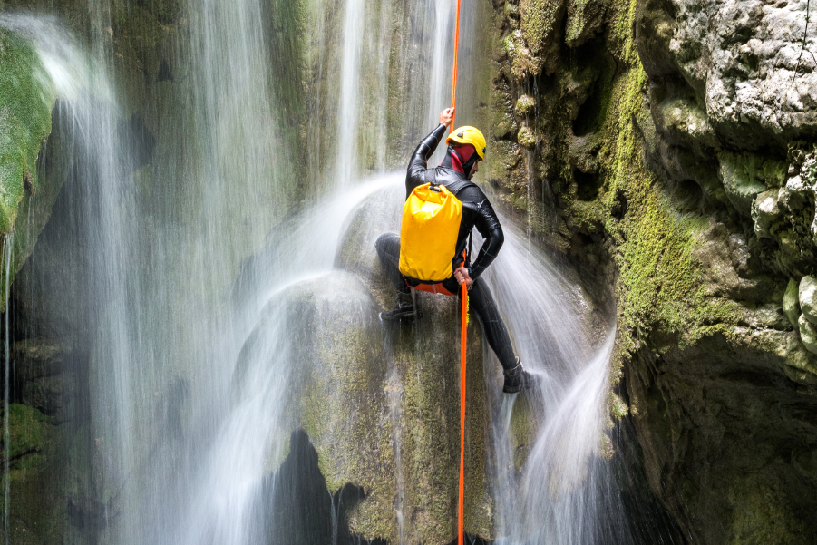 Persona escalando en una cascada