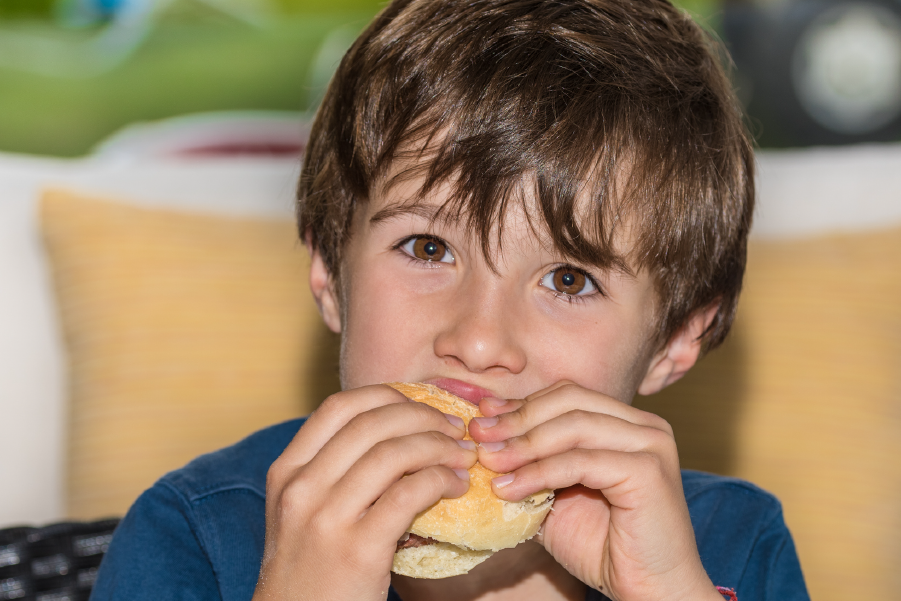 Un niño comiendo chipa en Asunción